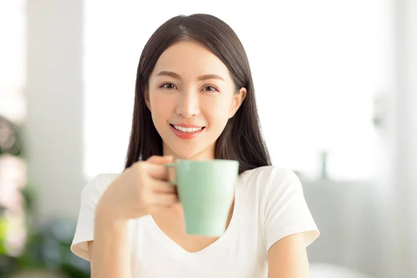自宅の居間でお茶を飲んでいる美しい若い女性 — ストック写真