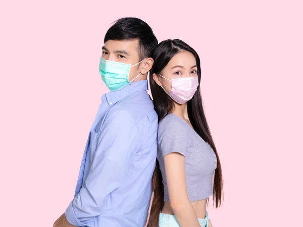 Genç Çift Ayakta Tıbbi Maske Takıyor Pembe Arka Planda Izole — Stok fotoğraf