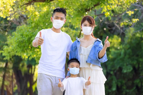 Glückliche Familie Trägt Zum Schutz Medizinische Masken Und Zeigt Daumen — Stockfoto