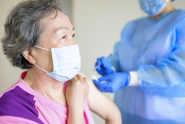 Läkare Som Injicerar Vaccin Till Äldre Kvinnor — Stockfoto