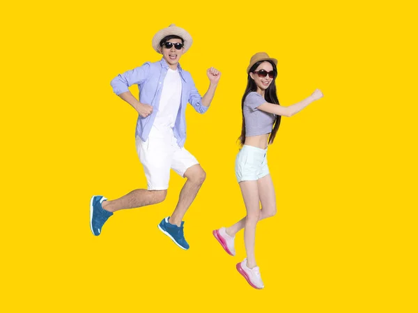 Gelukkig Jong Paar Zonnebril Springen Geïsoleerd Gele Achtergrond — Stockfoto
