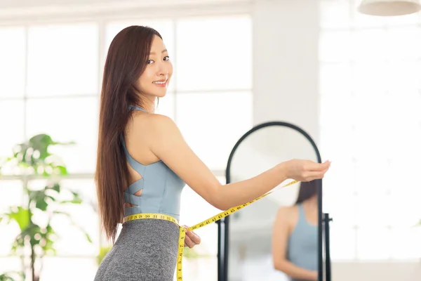 Jovem Mulher Medindo Cintura Com Fita Frente Espelho Conceito Perda — Fotografia de Stock