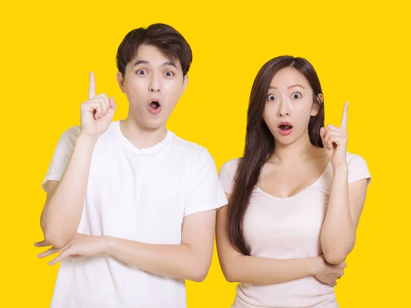 Young Couple Pointing Fingers Aside Together Isolated Yellow Background — Stock Photo, Image