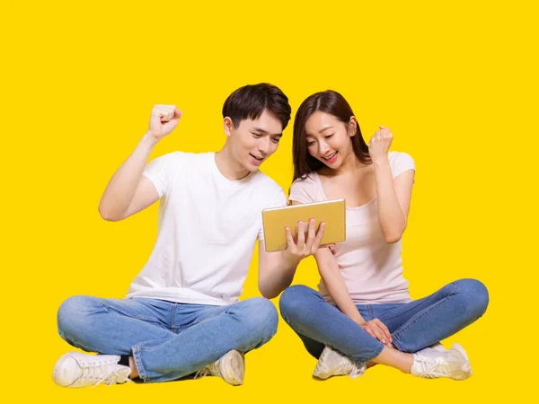 Pareja Joven Feliz Utilizando Tableta Computer Isolated Sobre Fondo Amarillo —  Fotos de Stock