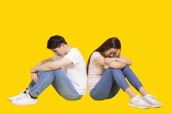 Young Couple Sitting Back Back Looking Isolated Yellow Background — Stock Photo, Image