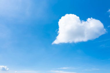 Temiz mavi gökyüzünde kalp şeklinde güzel bulutlar.