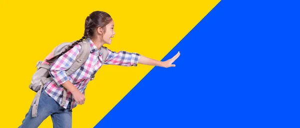 通学袋付きの幸せな学生の女の子 何かに触れる 黄色と青の背景に隔離された — ストック写真