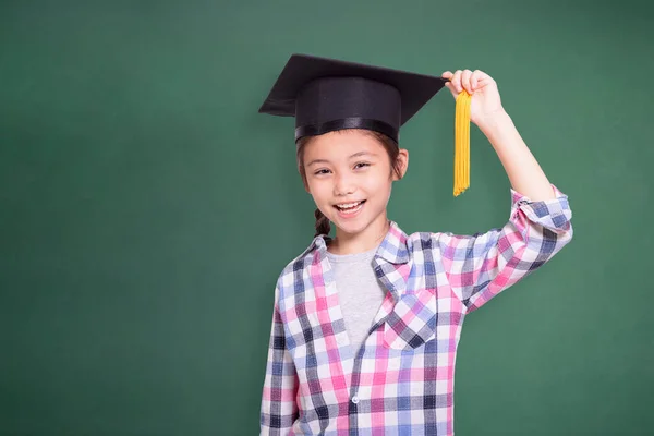 幸せな学生の女の子身に着けています卒業キャップ グリーン黒板の背景に孤立 — ストック写真