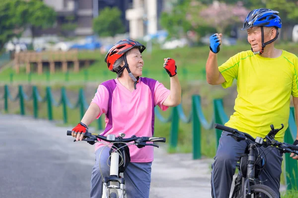 Szczęśliwa Azjatycka Para Seniorów Ćwiczących Rowerach Pokazujących Gest Sukcesu — Zdjęcie stockowe