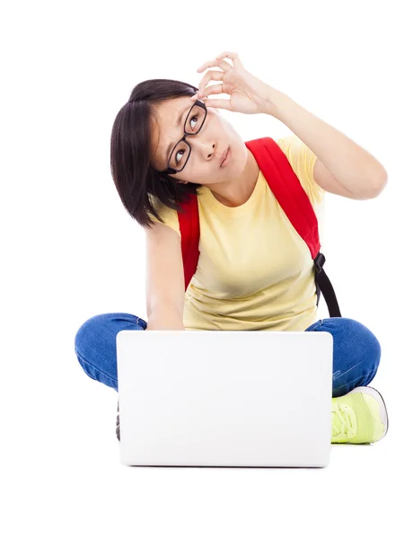 Zweifelhafte junge Studentin sitzt mit Laptop auf dem Boden — Stockfoto