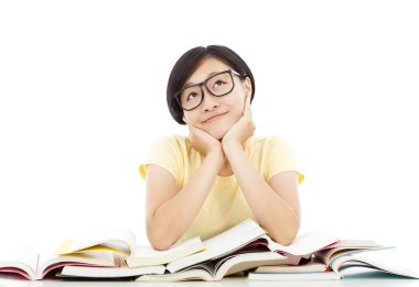 Genç öğrenci kız masanın üzerinde kitap ile düşünme gülümseyen