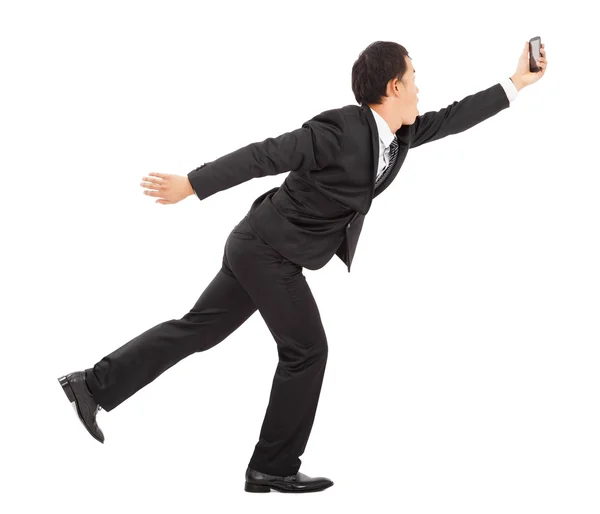 Business man running busily and holding a smart phone — стоковое фото