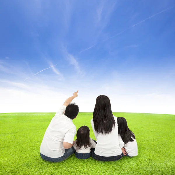Glückliche Familie auf einer Wiese mit Wolkenhintergrund — Stockfoto