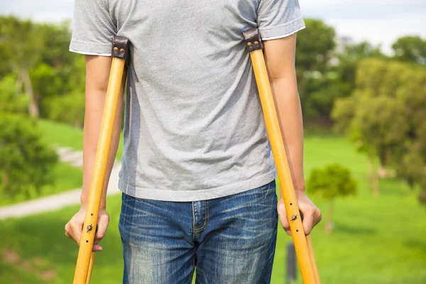 Close-up de perna em bandagem com muletas — Fotografia de Stock