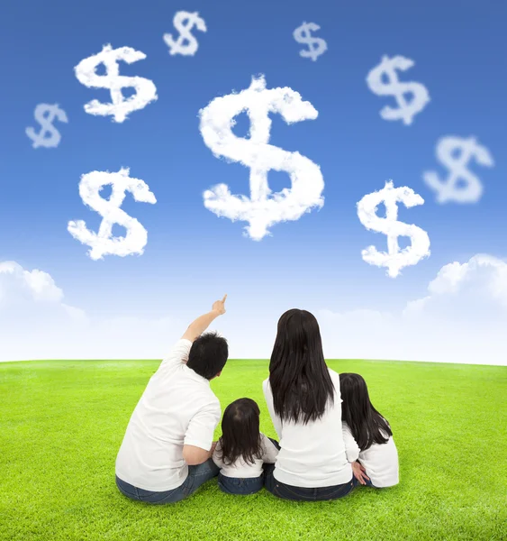 Family sitting on a meadow with money of clouds — Stock Photo, Image