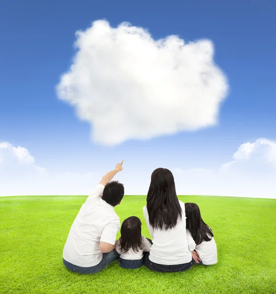 Ευτυχισμένη οικογένεια σε ένα λιβάδι με φόντο σύννεφο — Φωτογραφία Αρχείου
