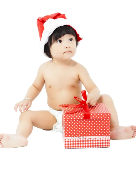 Noel Baba şapkalı Noel hediye ile katta oturan bebek — Stok fotoğraf
