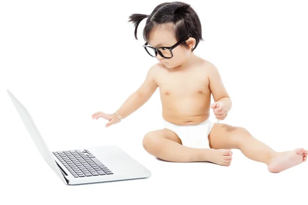 Criança sentada brincando em um laptop. isolado em branco — Fotografia de Stock