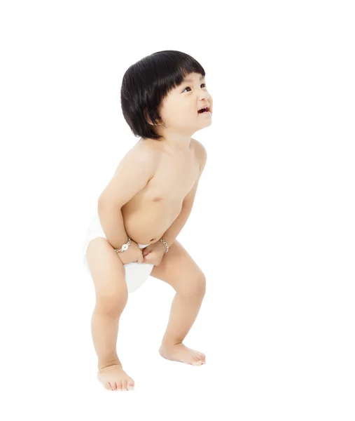 Happy baby girl in a diaper standing and looks up — Stock Photo, Image