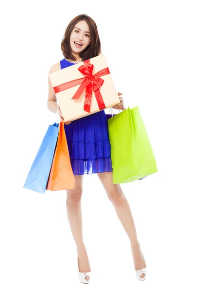 Sonriente joven mujer sosteniendo bolsa de compras y una caja de regalo —  Fotos de Stock