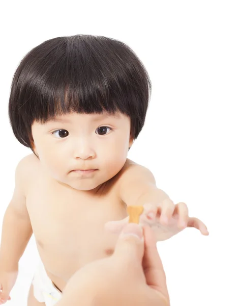 Cute baby girl  focus on the cookie and take it — Stock Photo, Image
