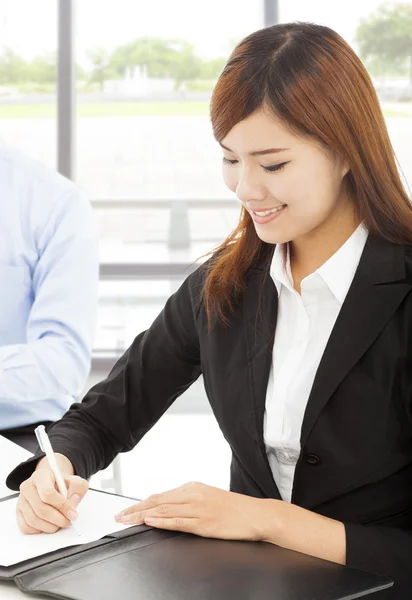 Young business woman writing document with colleague — Stock Photo, Image