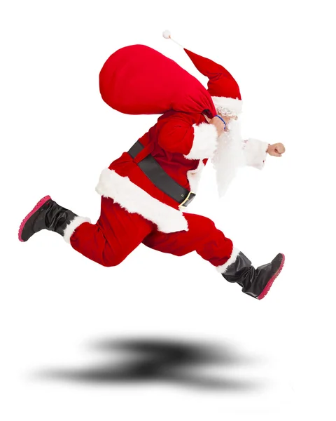Frohe Weihnachten Weihnachtsmann hält Geschenktüte und läuft. — Stockfoto