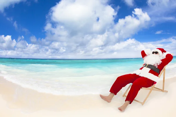 Santa claus siedzi na leżaki. Boże Narodzenie wakacje koncepcja. — Zdjęcie stockowe