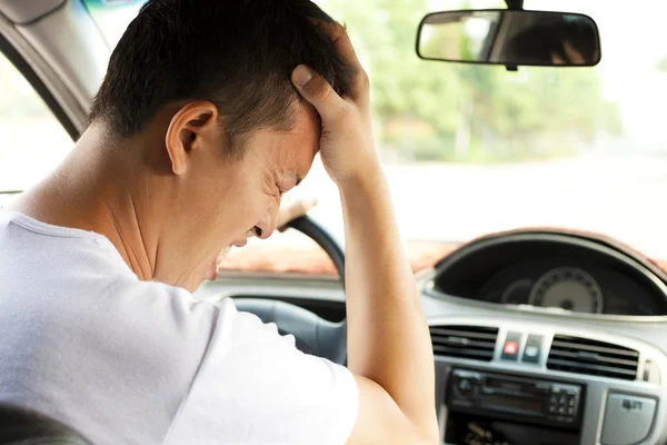 Joven cansado tiene un dolor de cabeza mientras conduce el coche — Foto de Stock