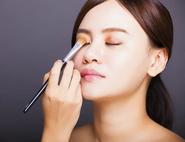 Make-up-Artist trägt farbigen Lidschatten auf das Auge des Models auf — Stockfoto