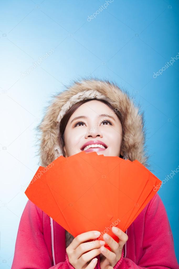 happy asian girl with winter wear and holding red bag for chines