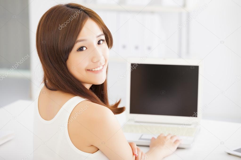 happy young asian woman using a laptop at home