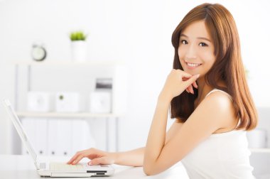 mutlu genç Asyalı kadın bir dizüstü bilgisayar kullanarak