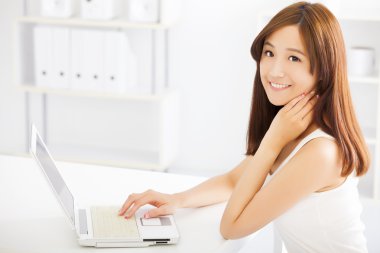 mutlu genç Asyalı kadın bir dizüstü bilgisayar kullanarak