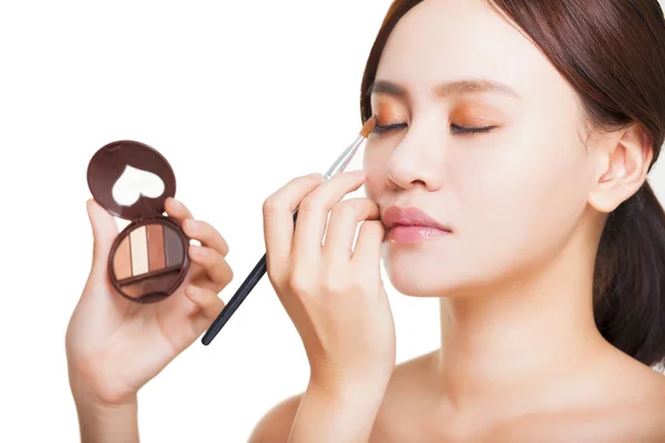 Maquillaje artista aplicando sombra de ojos de colores en el ojo de la modelo con un —  Fotos de Stock