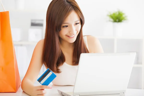 Молода жінка купує онлайн з кредитною карткою та ноутбуком — стокове фото
