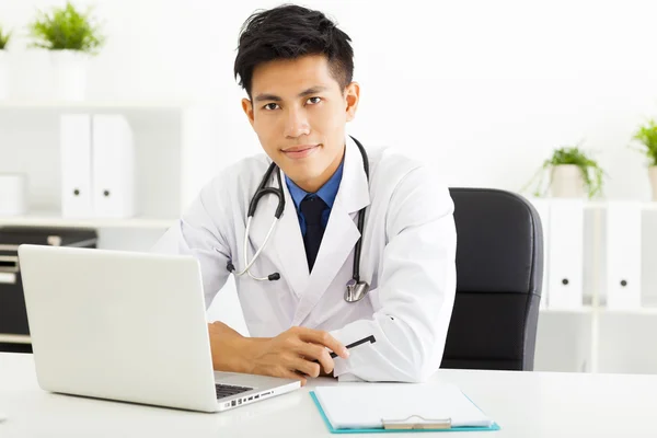 Unga asiatiska läkare arbetar med laptop i office — Stockfoto