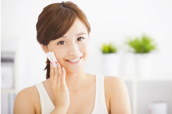 Krásná asijská mladá žena čištění její tvář s bavlnou — Stock fotografie