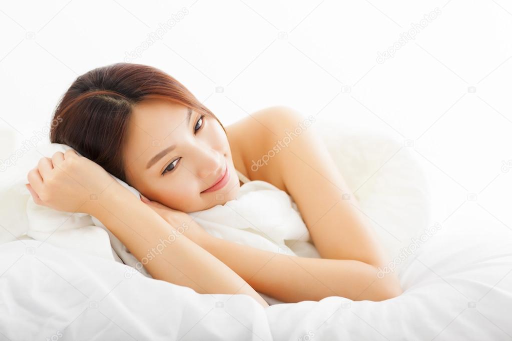 young Beautiful asian woman relaxing on the bed