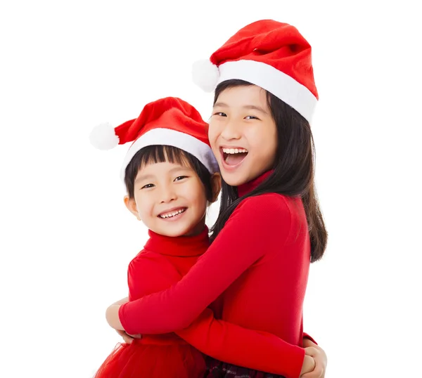 Joyeuses petites filles avec chapeau de Noël et donner un autre câlin — Photo