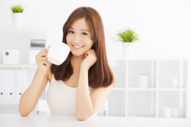 Mutlu Asyalı genç kahve içiyor.