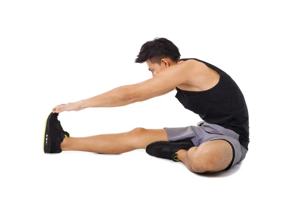 Fitness mężczyzna siedzi i podejmowania ćwiczenia rozciągające — Zdjęcie stockowe