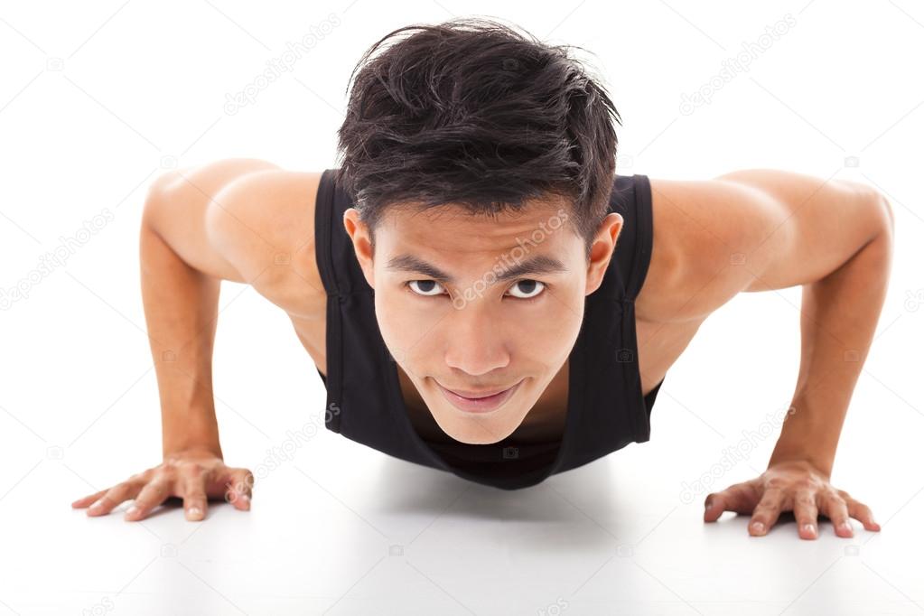 smiling young fitness man exercising push up