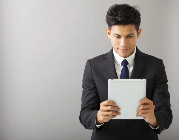 Mladý usmívající se podnikatel sledovat počítače tablet pc — Stock fotografie