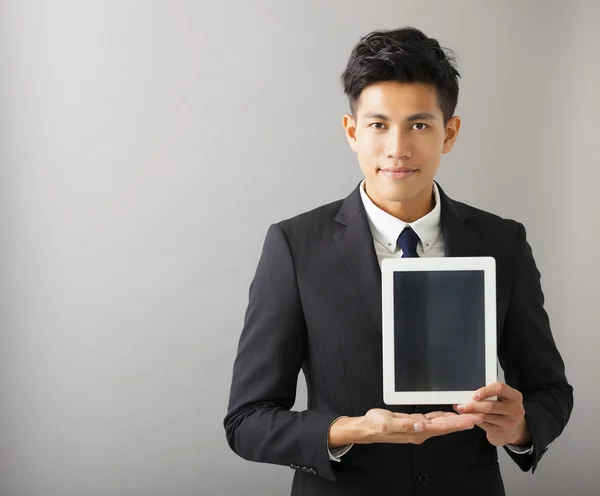 Mladý, usměvavý obchodník ukazující počítače tablet pc — Stock fotografie