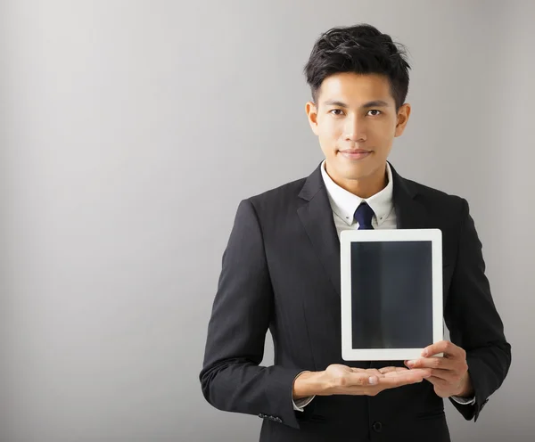 Joven sonriente hombre de negocios mostrando tableta pc —  Fotos de Stock