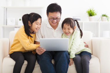 mutlu baba küçük kızlarla dizüstü bilgisayar kullanarak