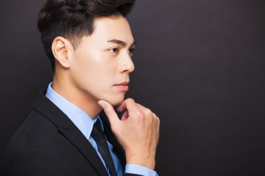 yan görüntülemek siyah arka plan üzerinde duran gülen işadamı