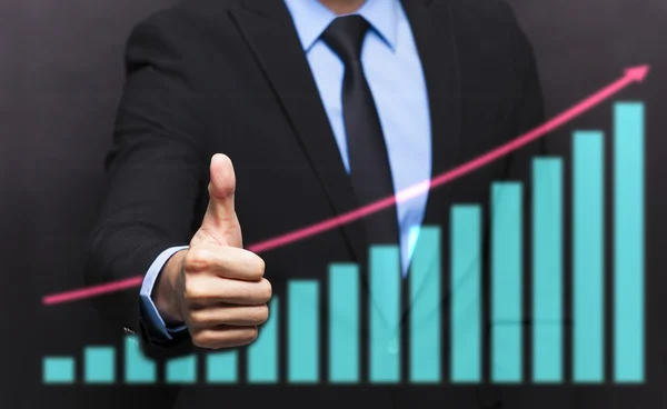 Business man with thumb up gesture and business growing graph — стоковое фото