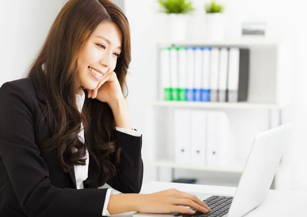 Sonriente joven mujer de negocios trabajando con el ordenador portátil —  Fotos de Stock